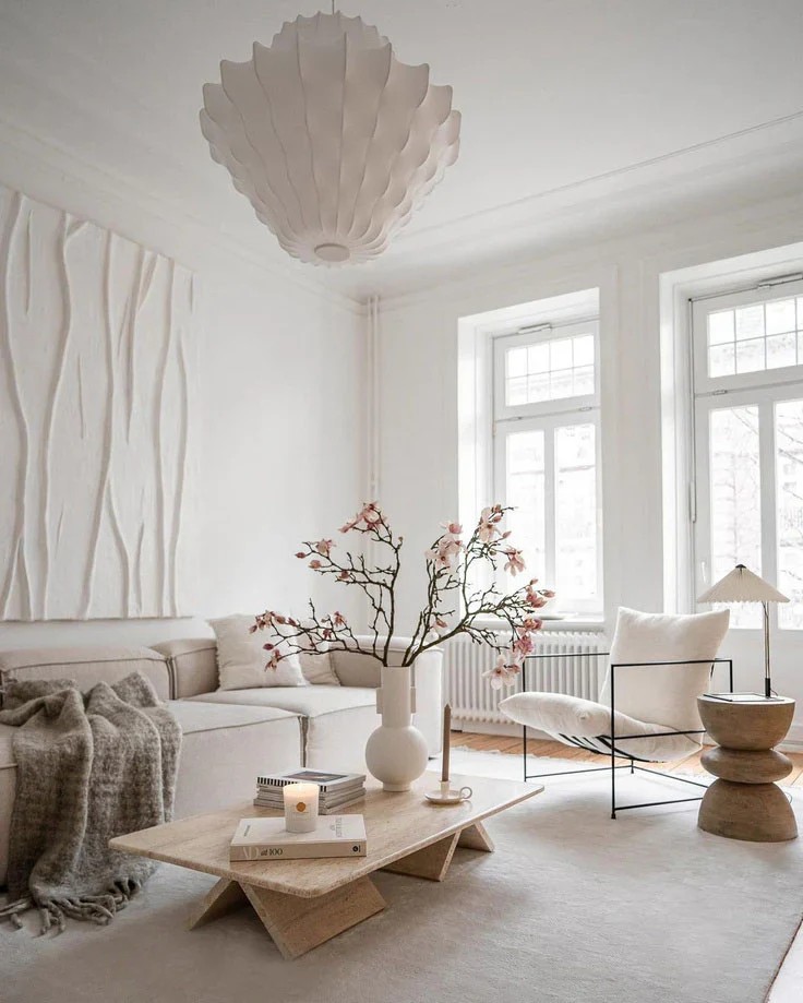 Warm, modern living room with a neutral sofa, wood accents, and natural light