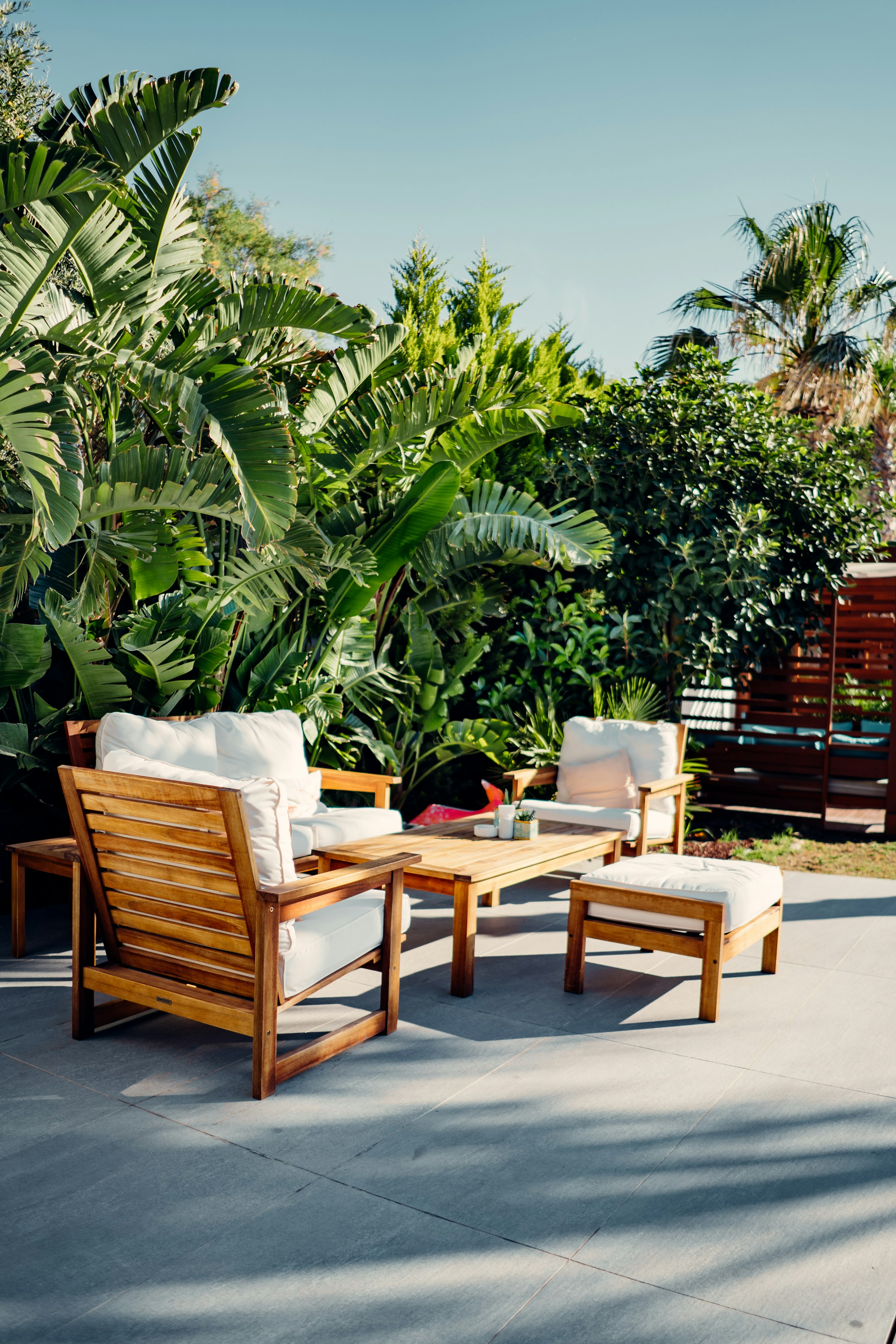 Covered patio with an outdoor sofa, lounge chairs, low table, and planters